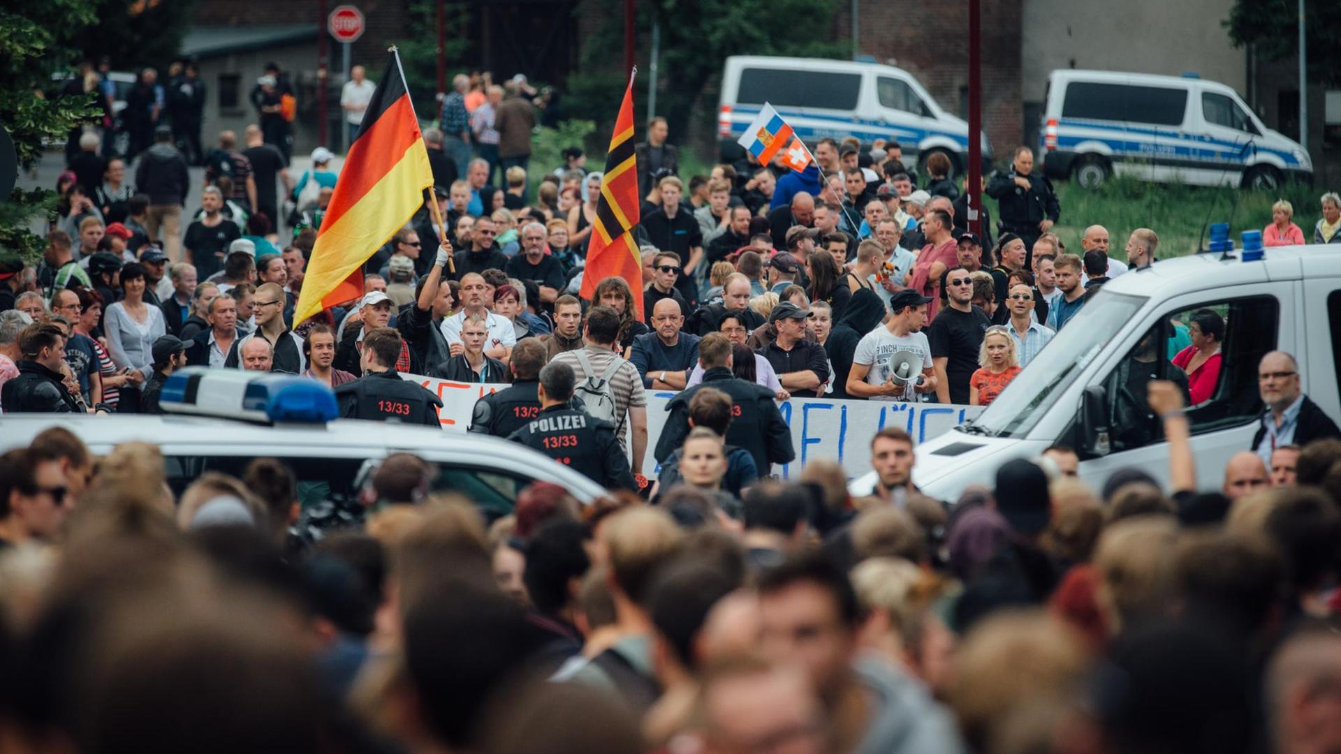 Gegner der Flüchtlingsunterkunft stehen am 26.06.2015 in Freital (Sachsen) in der Nähe des ehemaligen Leonardo-Hotels, das jetzt als Flüchtlingsheim dient.