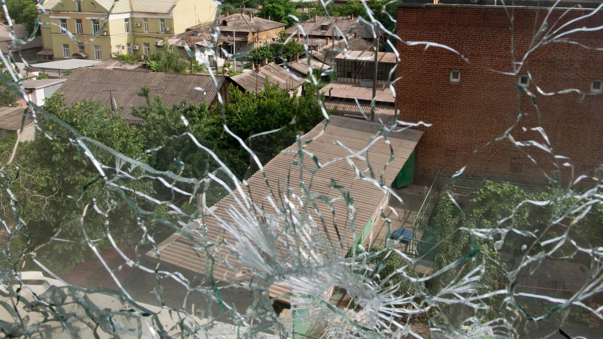 Blick aus einem von Kugeln zerstörten Fenster in der ostukrainischen Stadt Mariupol am Asowschen Meer