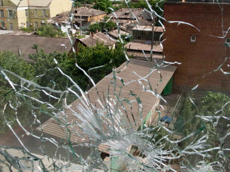 Blick aus einem von Kugeln zerstörten Fenster in der ostukrainischen Stadt Mariupol am Asowschen Meer