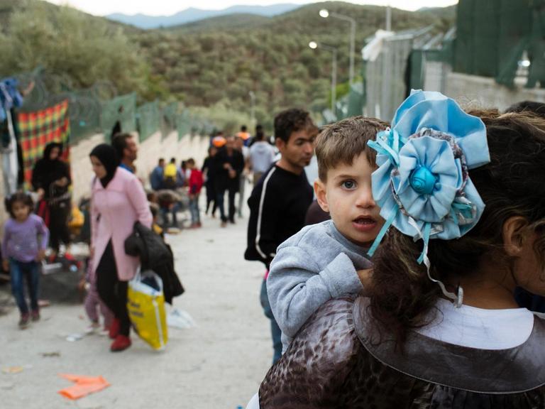 Ein Flüchtlingskind schaut über die Schulter seiner Mutter in einem Flüchtlingslager in Moria auf der griechischen Insel Lesbos.