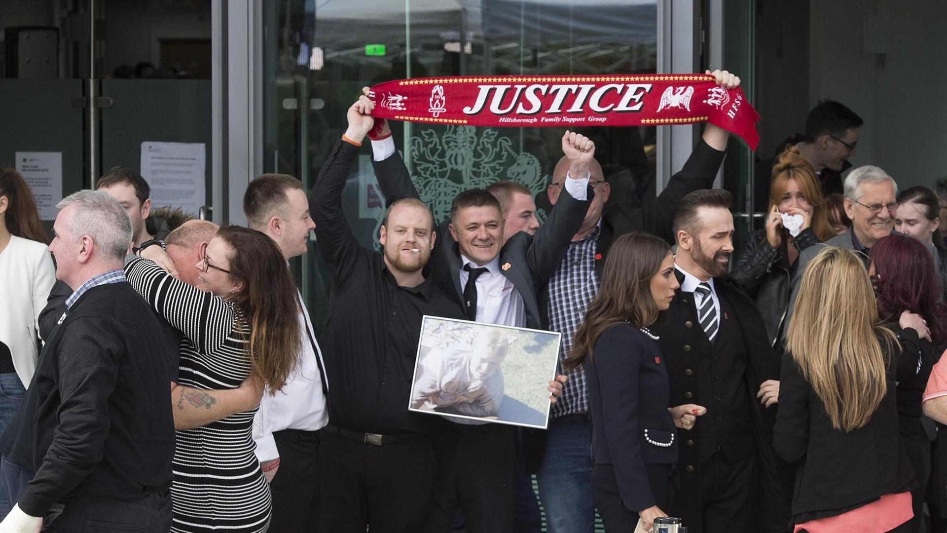 Angehörige der Opfer von Hillsborough halten einen Schal mit der Aufschrift "Gerechtigkeit" hoch nach dem Urteil einer Untersuchungskommission.