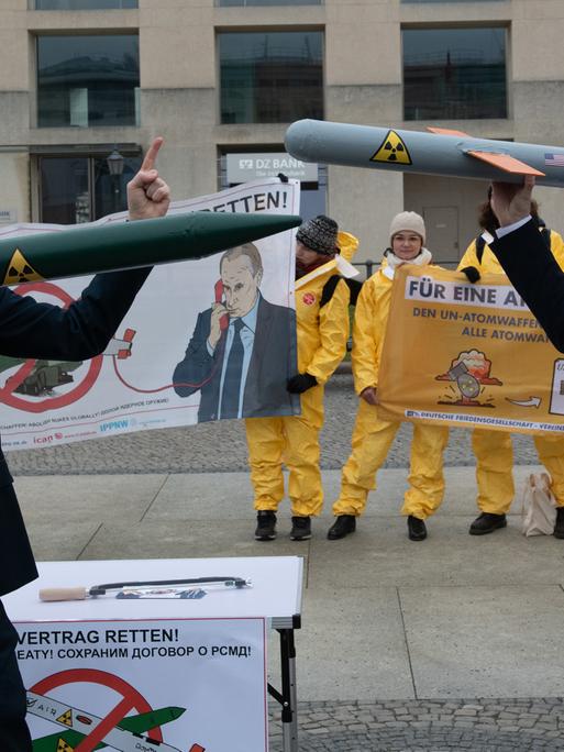 Berlin, Anfang Februar 2019: Demonstranten mit einer Putin und Trump-Maske stehen sich mit Raketen-Modellen auf dem Pariser Platz gegenüber. Sie protestieren mit der Aktion gegen das drohende Aus des INF-Abrüstungsabkommen zwischen Russland und den USA.