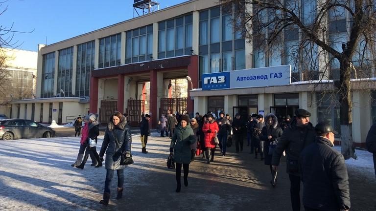 Menschen verlassen Fabrik nach Feierabend