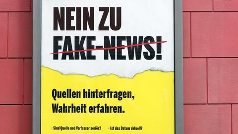 Ein fiktives Plakat gegen Fake News hängt in einer Filmkulisse der MMC Studios in Ossendorf.