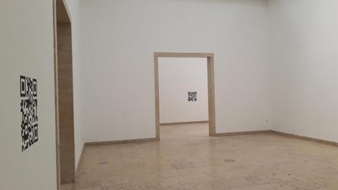 Blick in den deutschen Pavillon bei der 17. Architekturbiennale in Venedig. Der Pavillion ist leer, abgesehen davon, dass an einigen Wänden einzelne größere schwarz-weiße QR-Codes angebracht sind.