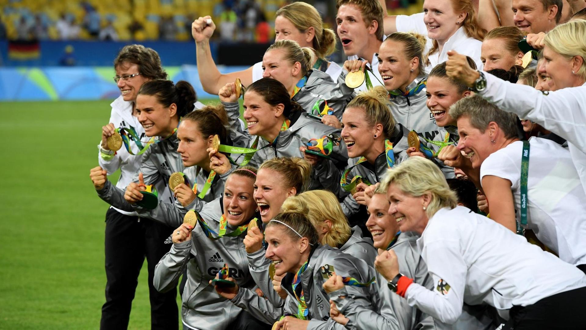 Ein Gruppenfoto der deutschen Frauen-Fußball-Nationalmannschaft mit Goldmedaillen.
