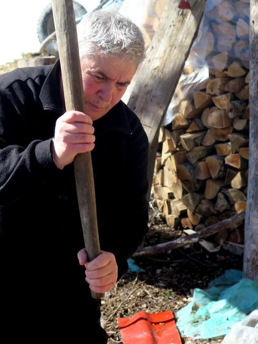 Eine der letzten "Schwurjungfrauen" Albaniens, Duni Grishaj, beim Holzhacken