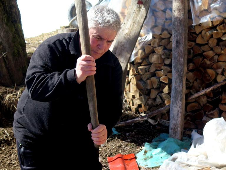 Eine der letzten "Schwurjungfrauen" Albaniens, Duni Grishaj, beim Holzhacken