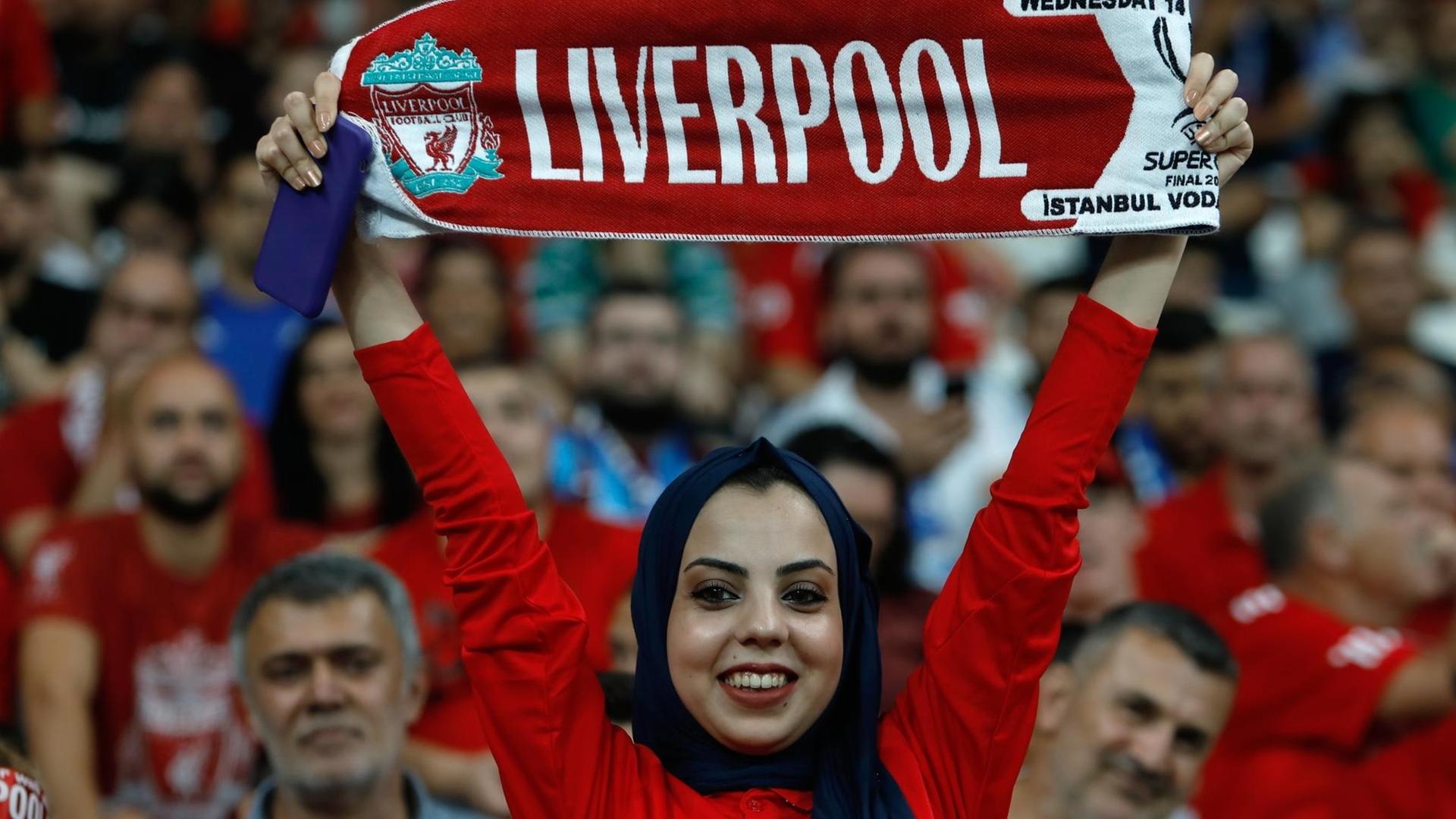 Eine Frau mit Kopftuch schwenkt einen Liverpool-Schal; beim Endspiel um den UEFA-Supercup gegen Chelsea in Istanbul