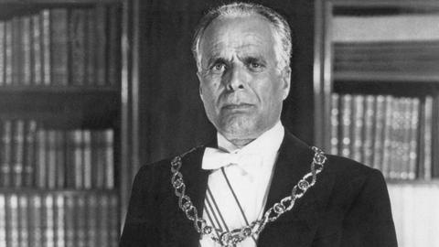 Der tunesische Staatspräsident Habib Bourguiba steht mit einem Orden behangen im Juli 1957 in seinem Amtssitz in Tunis.