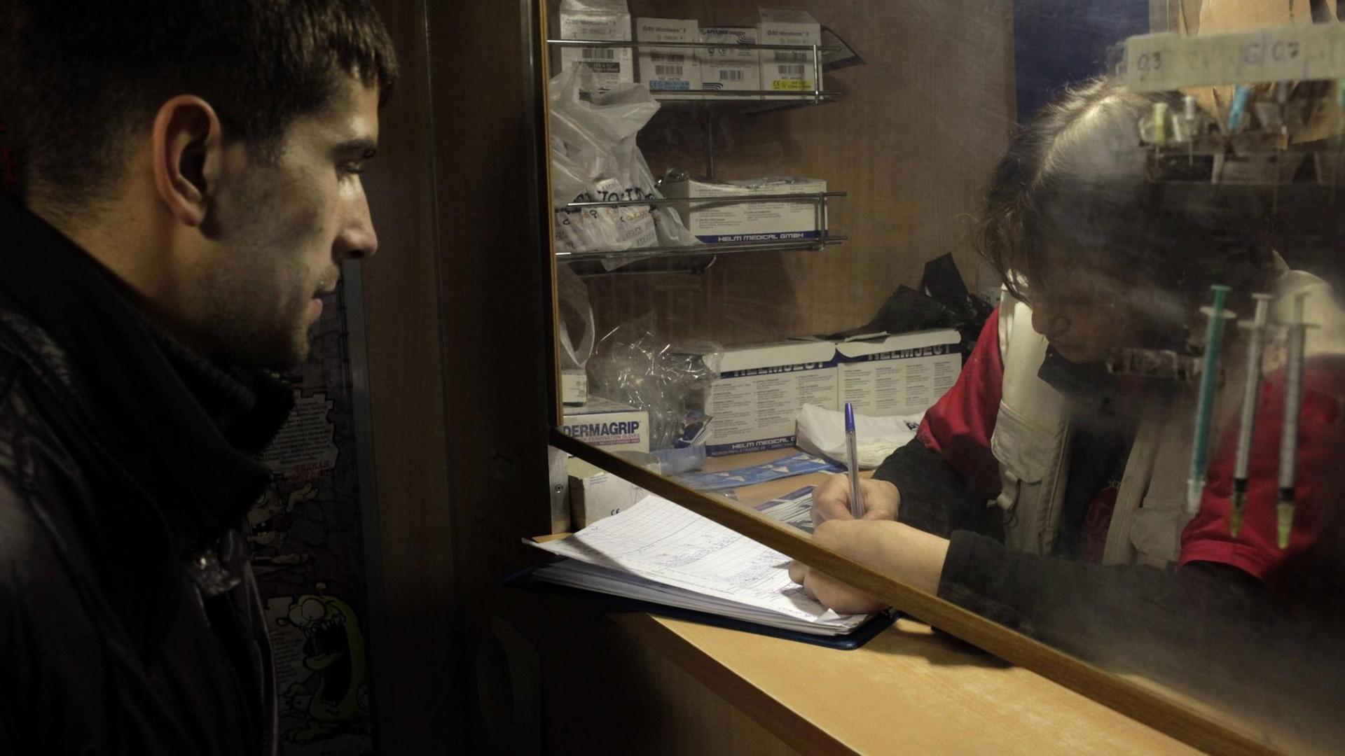 Heroinkranker Mann tauscht Nadeln bei einer mobilen medizinischen Einheit in St. Petersburg, Russland, aus. Fünfmal pro Woche bietet sie kostenlose Kondome, saubere Nadeln und Bluttests für HIV und Hepatitis an. 28.10.2010