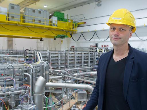 Der Direktor am Max-Planck-Institut für Plasmaphysik, Thomas Klinger, steht am 18.09.2015 in Greifswald (Mecklenburg-Vorpommern) vor dem 725 Tonnen schweren, ringförmigen Plasmagefäß für das Kernfusionsexperiment "Wendelstein 7-X".