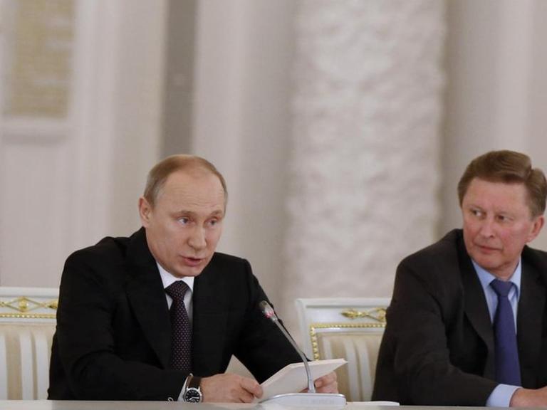 Russlands Präsident Wladimir Putin (l.) sitzt neben seinem bisherigen Stabschef Sergej Iwanow.