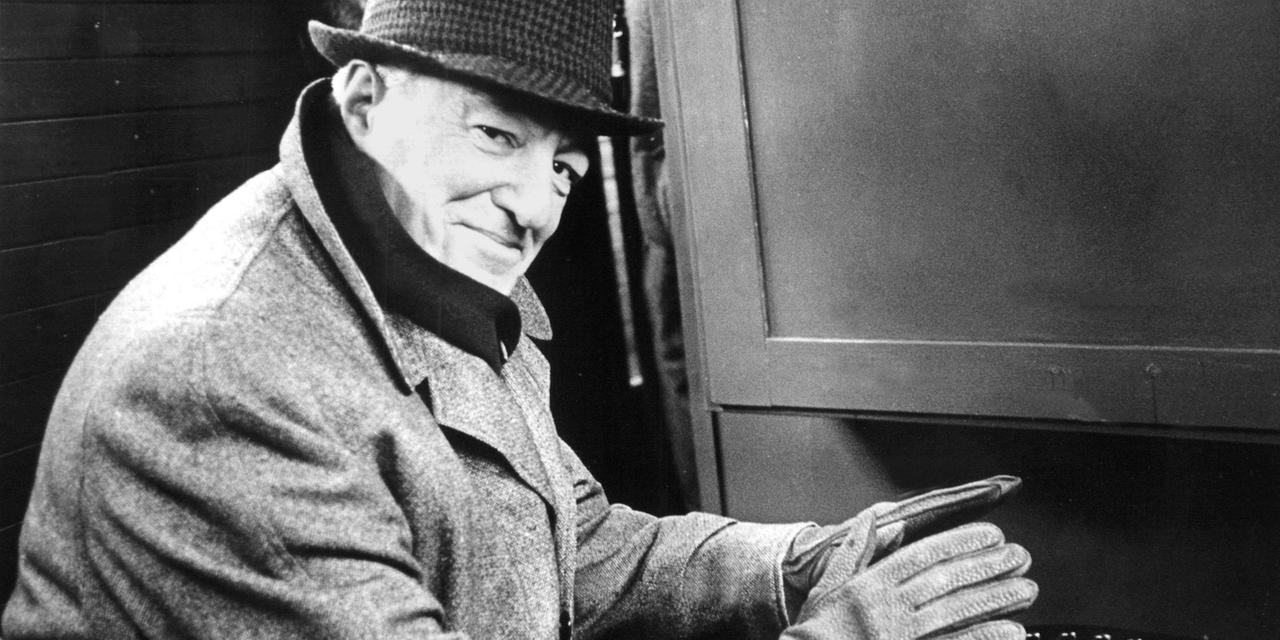 Der italienische Filmregisseur und Schauspieler Vittorio De Sica (1902 - 1974) wärmt sich während einer Hafenrundfahrt am 20. März 1962 in Hamburg die Hände an einem Ofen.