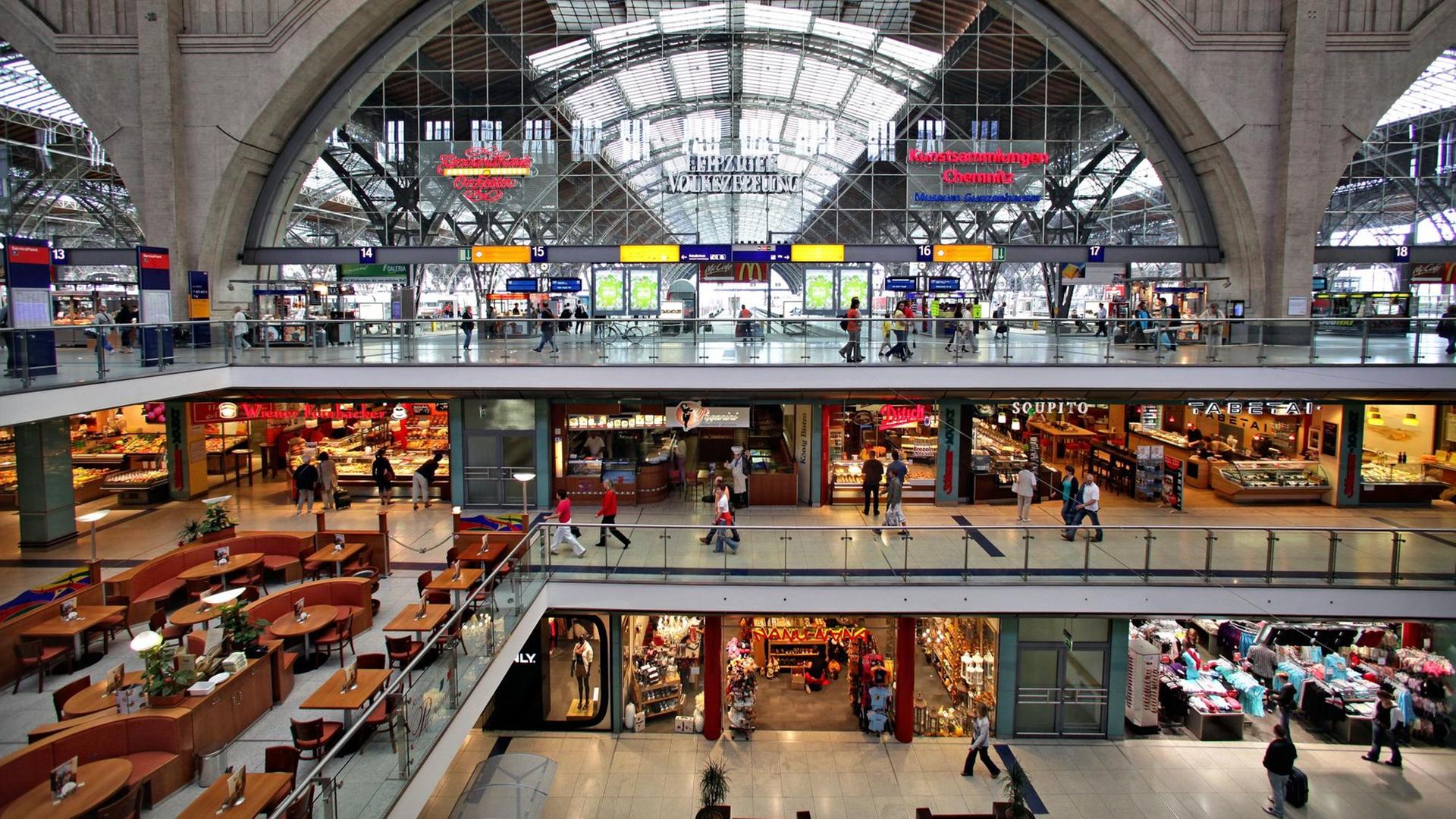 Reisende und Passanten laufen durch den Hauptbahnhof in Leipzig mit zahlreichen Geschäften. Reisende und Passanten laufen durch den Hauptbahnhof in Leipzig mit zahlreichen Geschäften.