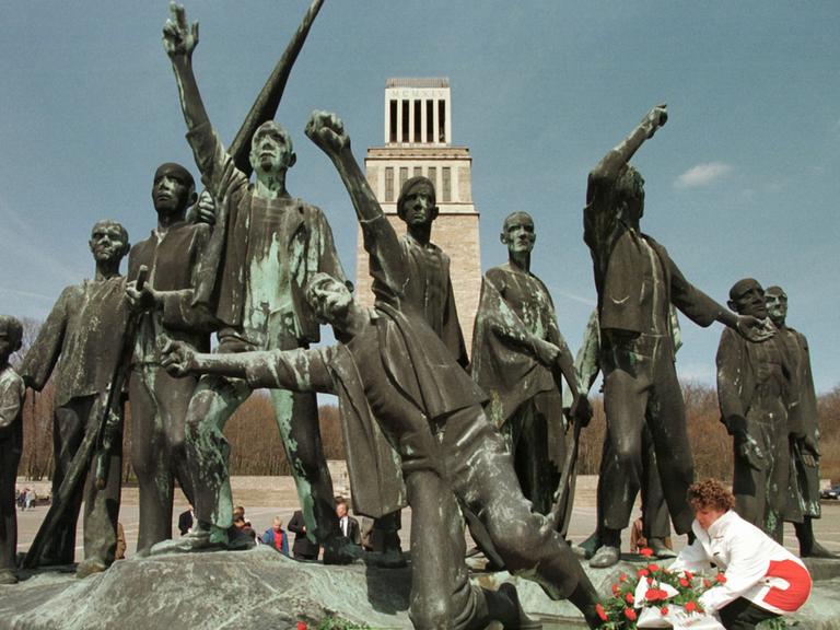 Besucher der Gedenkstätte im ehemaligen Konzentrationslager Weimar-Buchenwald legen Blumen und Kränze vor die Figurengruppe des Bildhauers Fritz Cremer, die den Tag der Befreiung des Lagers am 11. April 1945 symbolisiert.