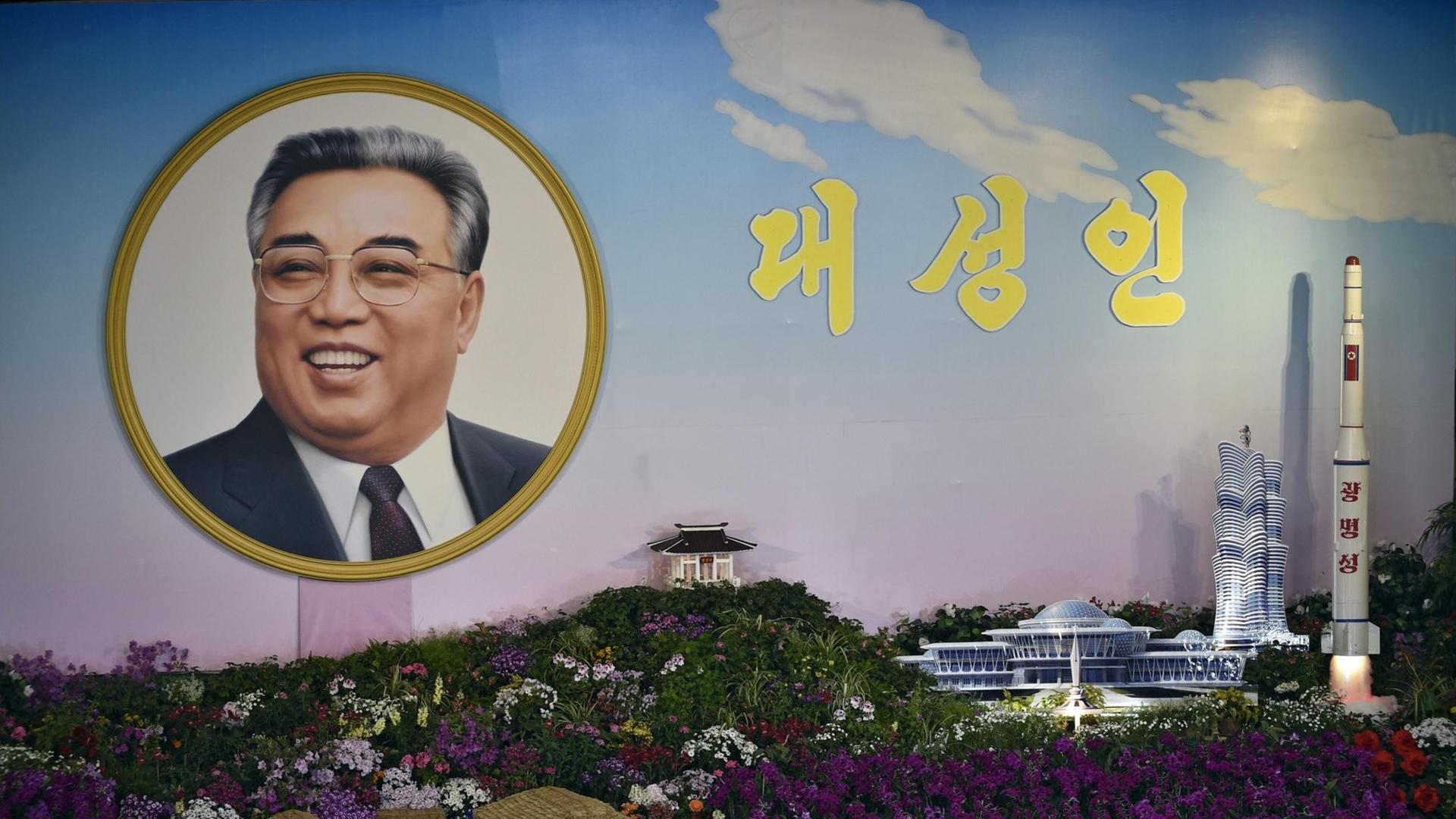 Ein Porträt des nordkoreanischen Staatsgründers Kim Il Sung neben einer Rakete in Pjöngjang.