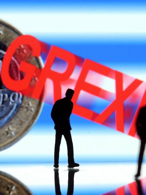 Ungewisse Zukunft Griechenlands: nachdenkliche Manager Figuren stehen vor griechischer Flagge und griechischem Euro mit Schriftzug Grexit