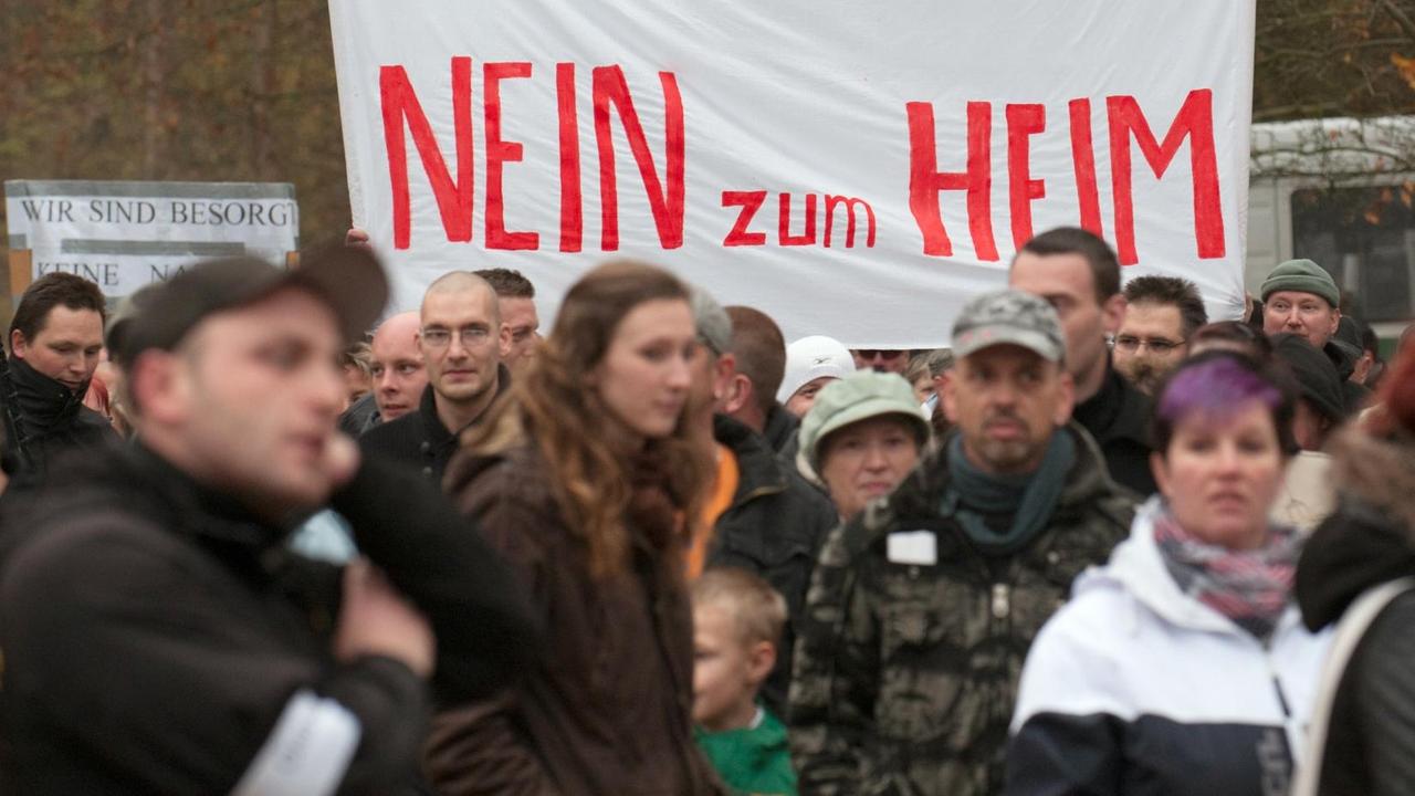 Demonstranten halten ein Plakat mit der Aufschrift "Nein zum Heim" bei einem Protest gegen eine Flüchtlingsunterkunft in Berlin-Köpenick.