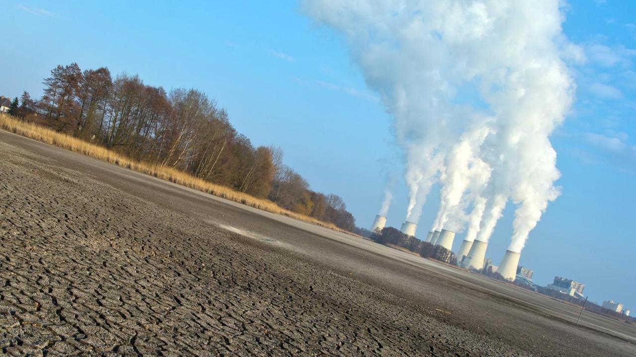 Ausgetrockneter Boden vor einem Kohlekraftwerk