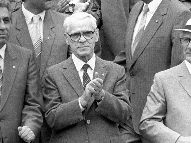 Der damalige DDR-Staatsratsvorsitzende Erich Honecker (rechts) mit dem Vorsitzenden des Ministerrates, Willy Stoph (Mitte) und Egon Krenz, Mitglied des Politbüros, auf der Ehrentribüne anlässlich der Feierlichkeiten zum 25-jährigen Jubiläum der Berliner Mauer im Jahr 1986 (Schwarz-Weiß-Aufnahme)