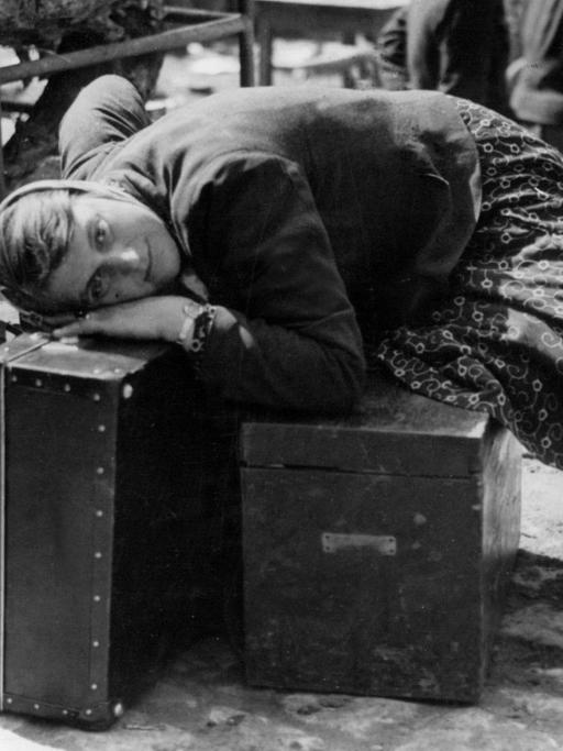 Ein erschöpfte russische Zwangsarbeiterin ruht sich im April 1945 in der Sammelstelle für Zwangsverschleppte in Würzburg auf Gepäckstücken aus. Sie war von Einheiten der 7. amerikanischen Armee befreit worden und wartet nun auf ihre Repatriierung.
