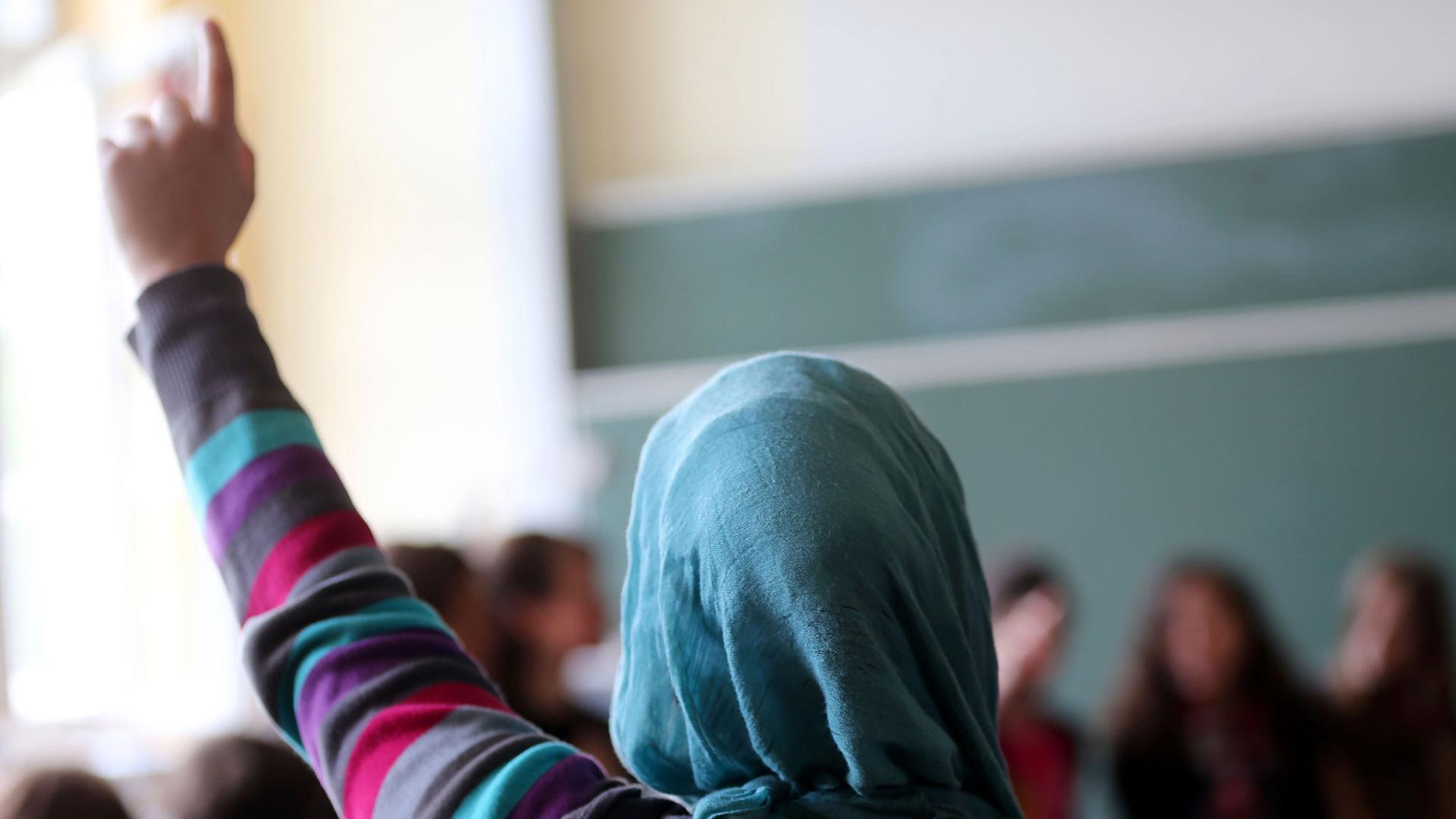 Eine Schülerin mit Kopftuch aus der Türkei meldet sich im Unterricht am 10.06.2013 in Oberhausen (Nordrhein-Westfalen)