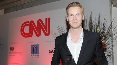 Der Journalist Claas Relotius präsentiert 2014 auf einer Gala in München seine Auszeichnung zum "CNN Journalist Of The Year".