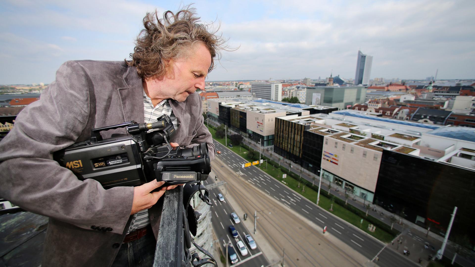 Der Journalist Siegbert Schefke steht mit seiner alten Videokamera auf dem Turm der Reformierten Kirche in Leipzig. Schefke filmte am 9. Oktober 1989 mit seinem Kollegen Aram Radomski eine Montagsdemo vom Turm der Kirche aus.
