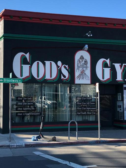 Außenansicht des "God's Gym" mit dem großen Titelschriftzug an der Wand.