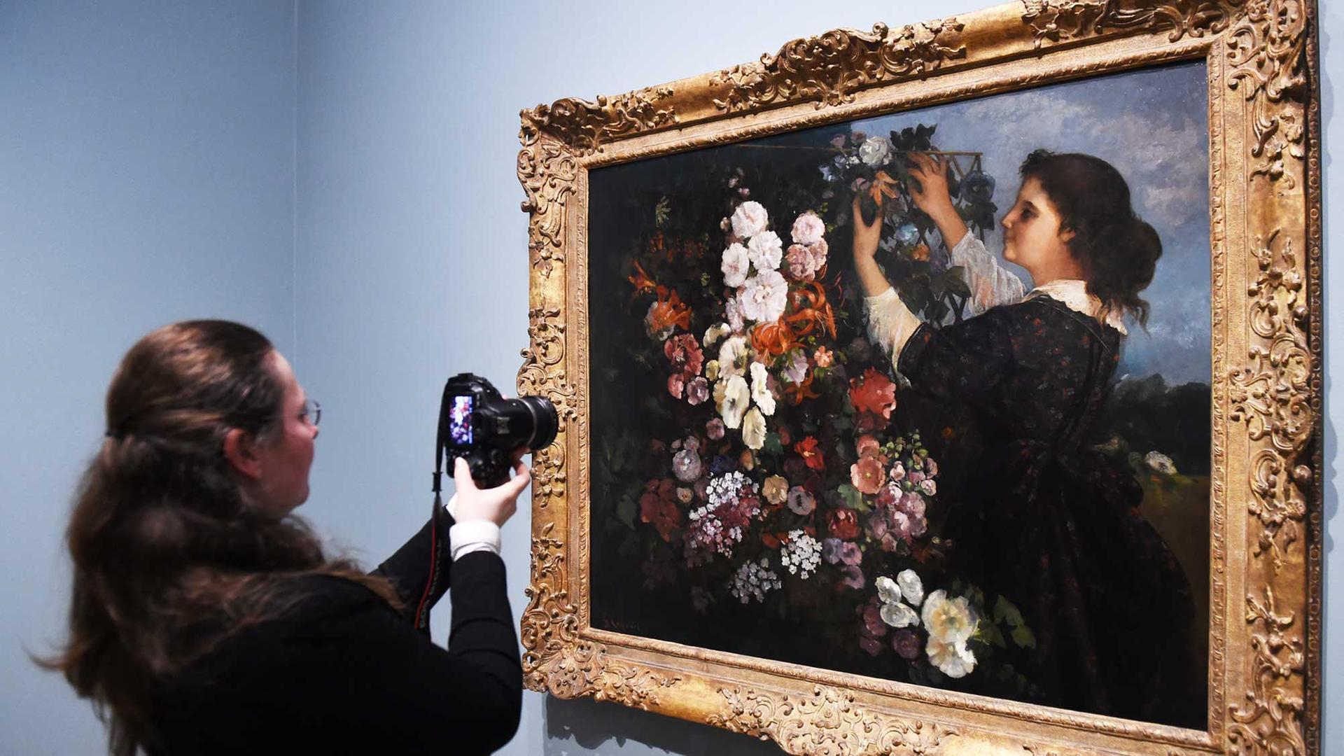 Eine Besucherin fotografiert das Gemälde "Les Trellis" von Gustave Courbet, das nach dem Vorbild des Malers Delacroix entstand. Es hängt in der Ausstellung "Delacroix and the rise of Modern art" in der National gallery in London.
