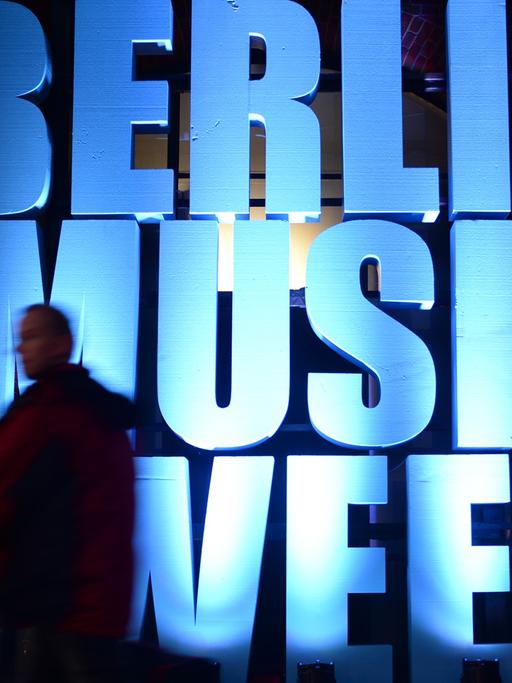 Ein Besucher geht an einem beleuchteten Schriftzug "Berlin Music Week" vorbei.