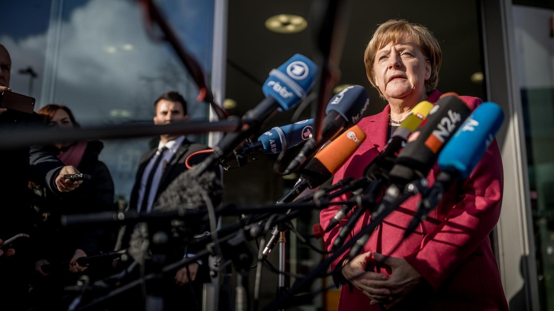 Bundeskanzlerin Angela Merkel äußert sich kurz vor der Fortsetzung der Sondierungsgespräche in Berlin vor Mikrofonen.