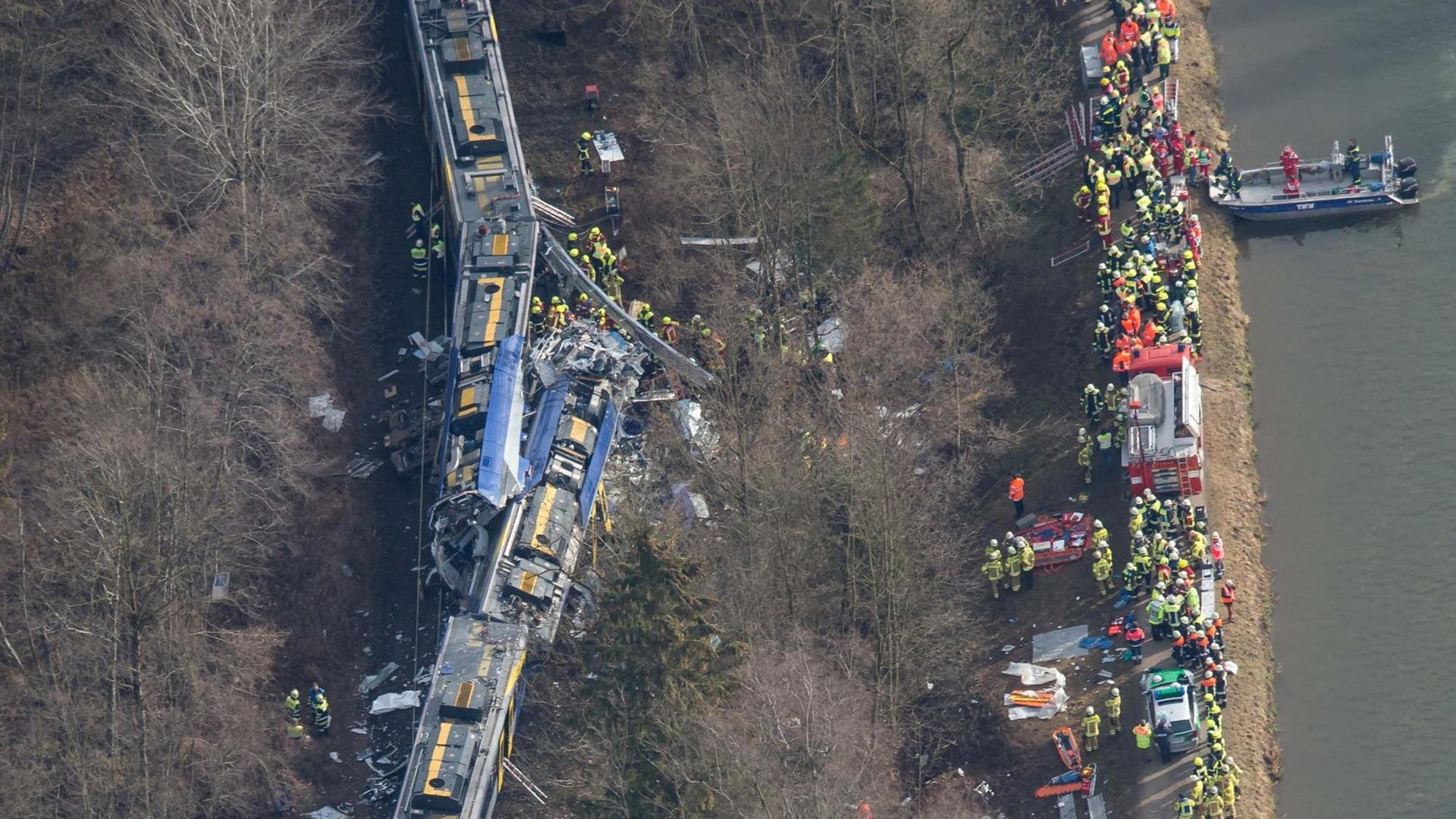 Rettungskräfte stehen an der Unfallstelle eines Zugunglücks in der Nähe von Bad Aibling.