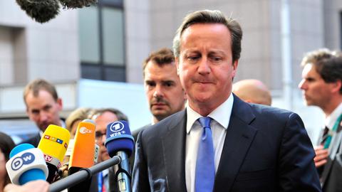 Der britische Premierminister David Cameron beim Gang in die Zentrale der Europäischen in Union in Brüssel, Pressevertreter halten ihm Mikrofone hin.