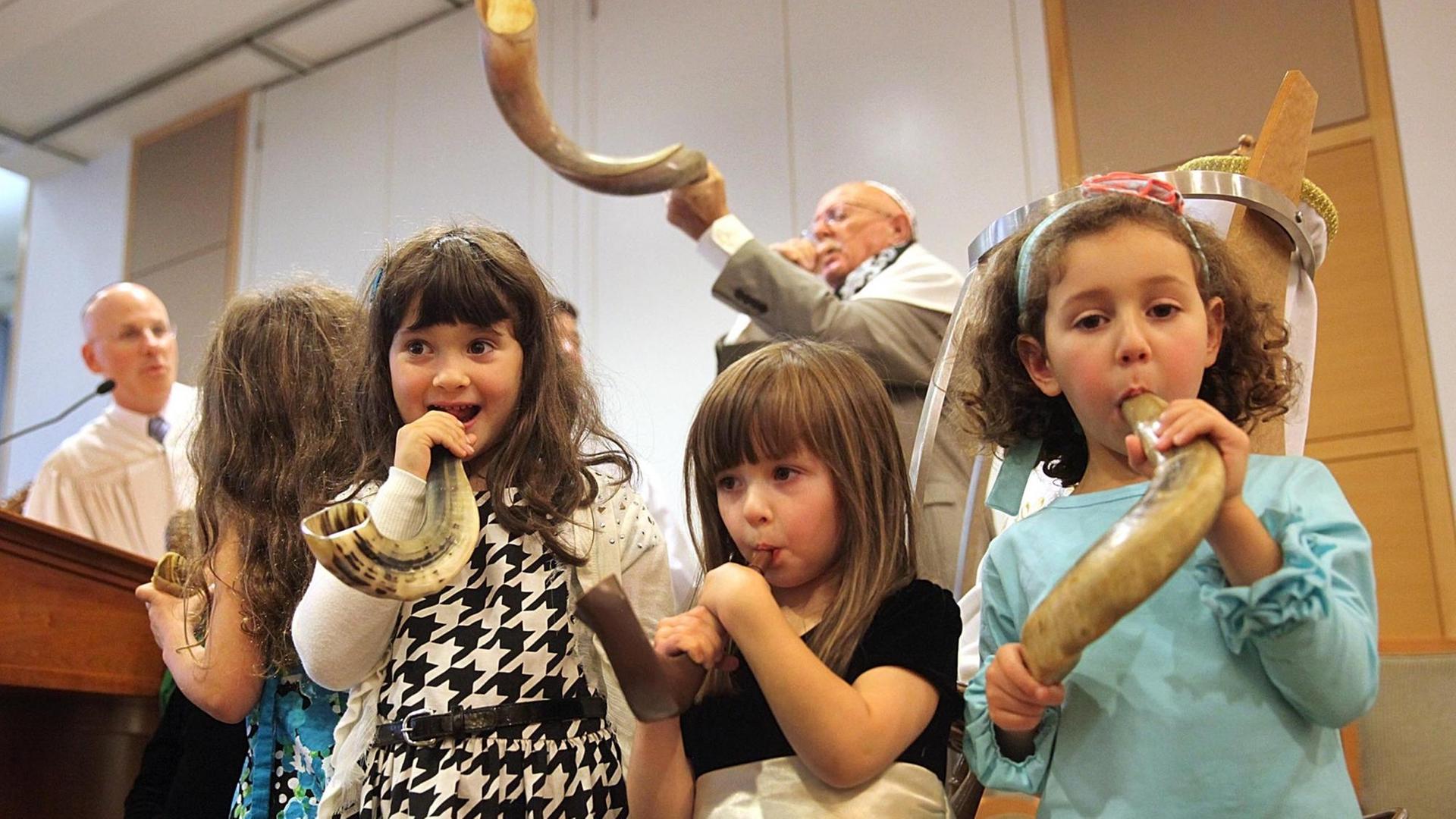 Rabbiner Jay Perlman, ganz links, schaut zu, wie die Kinder in der Gemeinde während eines Jom-Kippur Kindergottesdienstes im Tempel Beth Shalom in Needham, Massachusetts, ihr Shofar-Horn blasen.