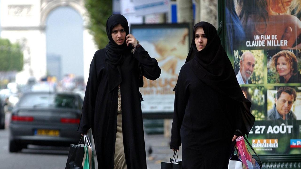 Verschleierte muslimische Frauen bei einem Einkaufsbummel auf der Pariser Champs-Élysées