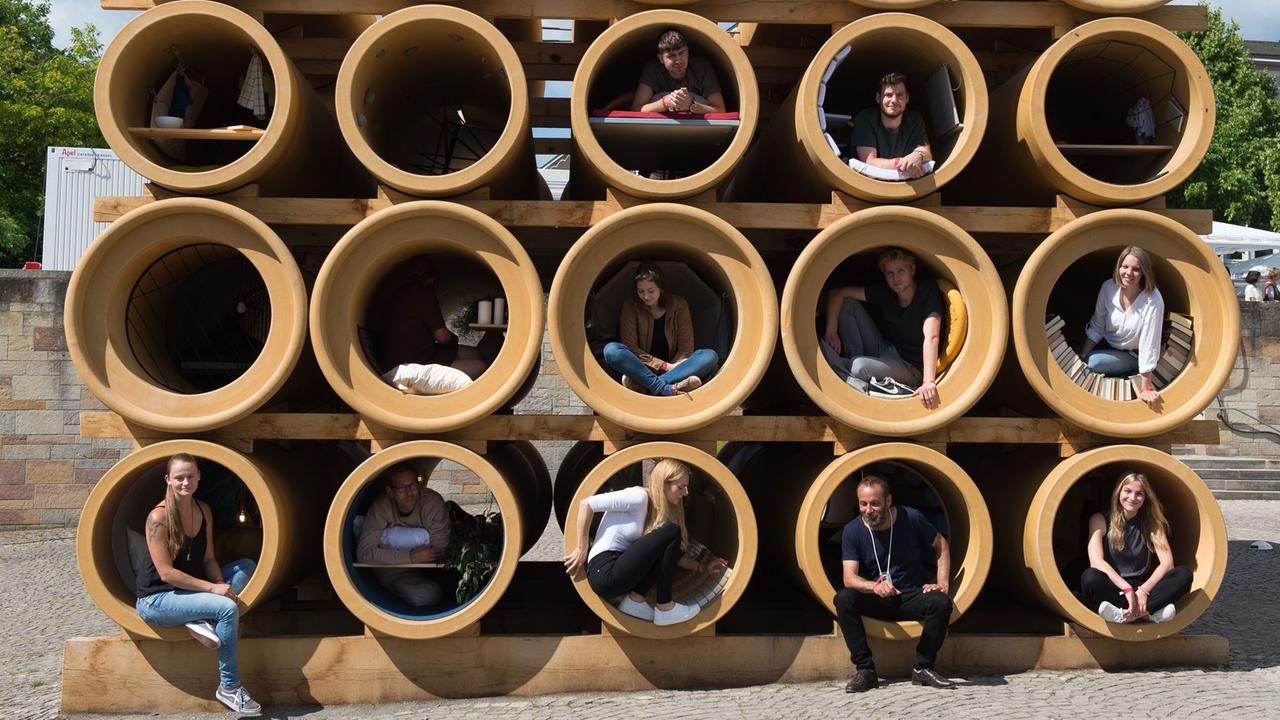 Installationskünstler Hiwa K. (unten, 2.v.r.) sitzt am 10.06.2017 bei der Eröffnung der documenta 14 in Kassel (Hessen) in einer Röhre seines Kunstwerks "When We Were Exhaling Images"