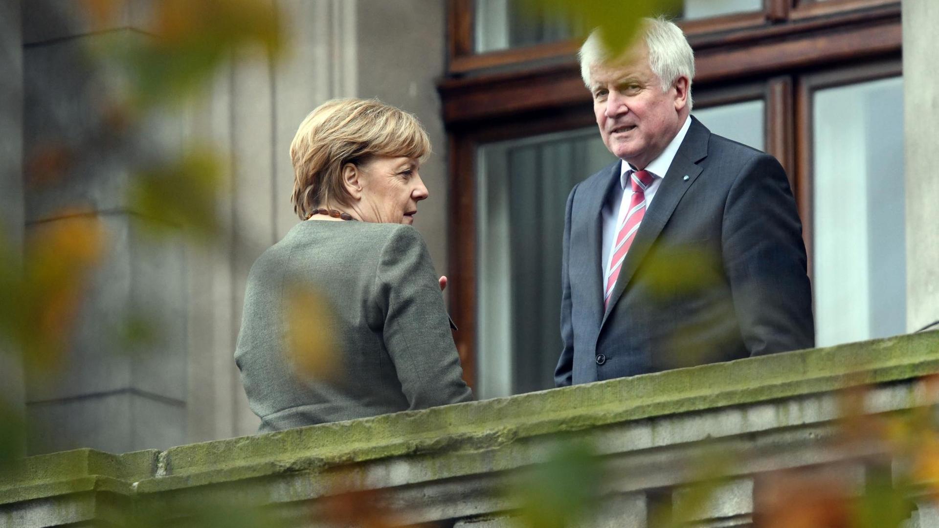 Bundeskanzlerin Angela Merkel (CDU) und Bayerns Ministerpräsident Horst Seehofer (CSU) stehen am 26.10.2017 in einer Verhandlungspause der Sondierungsverhandlungen zwischen CDU, CSU, FDP und Grünen auf dem Balkon der Parlamentarischen Gesellschaft.