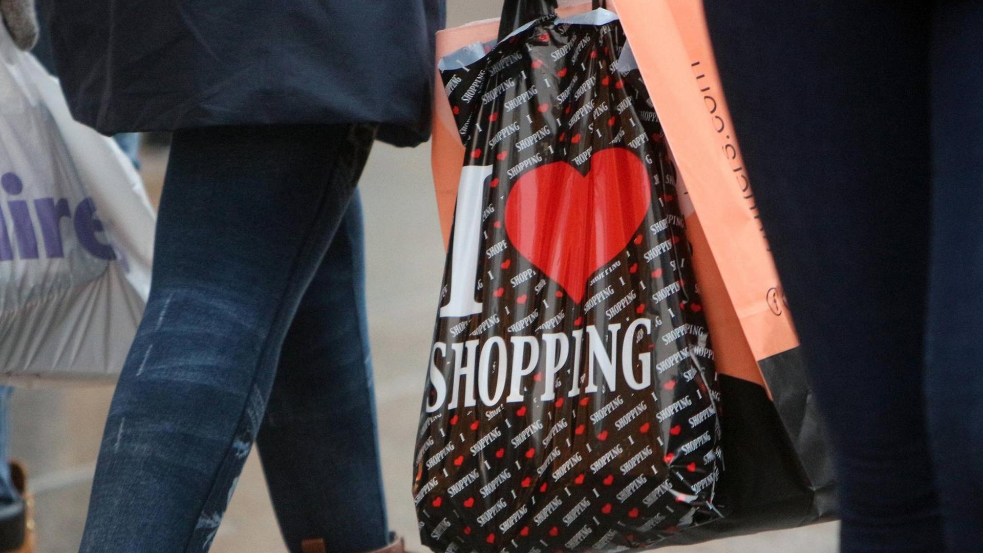 Frau trägt eine Plastiktüte mit Aufschrift "I Love Shopping"