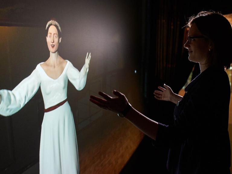 Eine Mitarbeiterin posiert am 31.08.2015 im Heinz Nixdorf MuseumsForum (HNF) in Paderborn mit einer computeranimierten Projektion der Ada Lovelace, der das erste Computerprogramm der Geschichte zugeschrieben wird. Das Computermuseum zeigt vom 02.09.2015 bis 10.07.2016 eine Ausstellung über Frauen in der Computergeschichte unter dem Titel "Am Anfang war Ada. Frauen in der Computergeschichte".