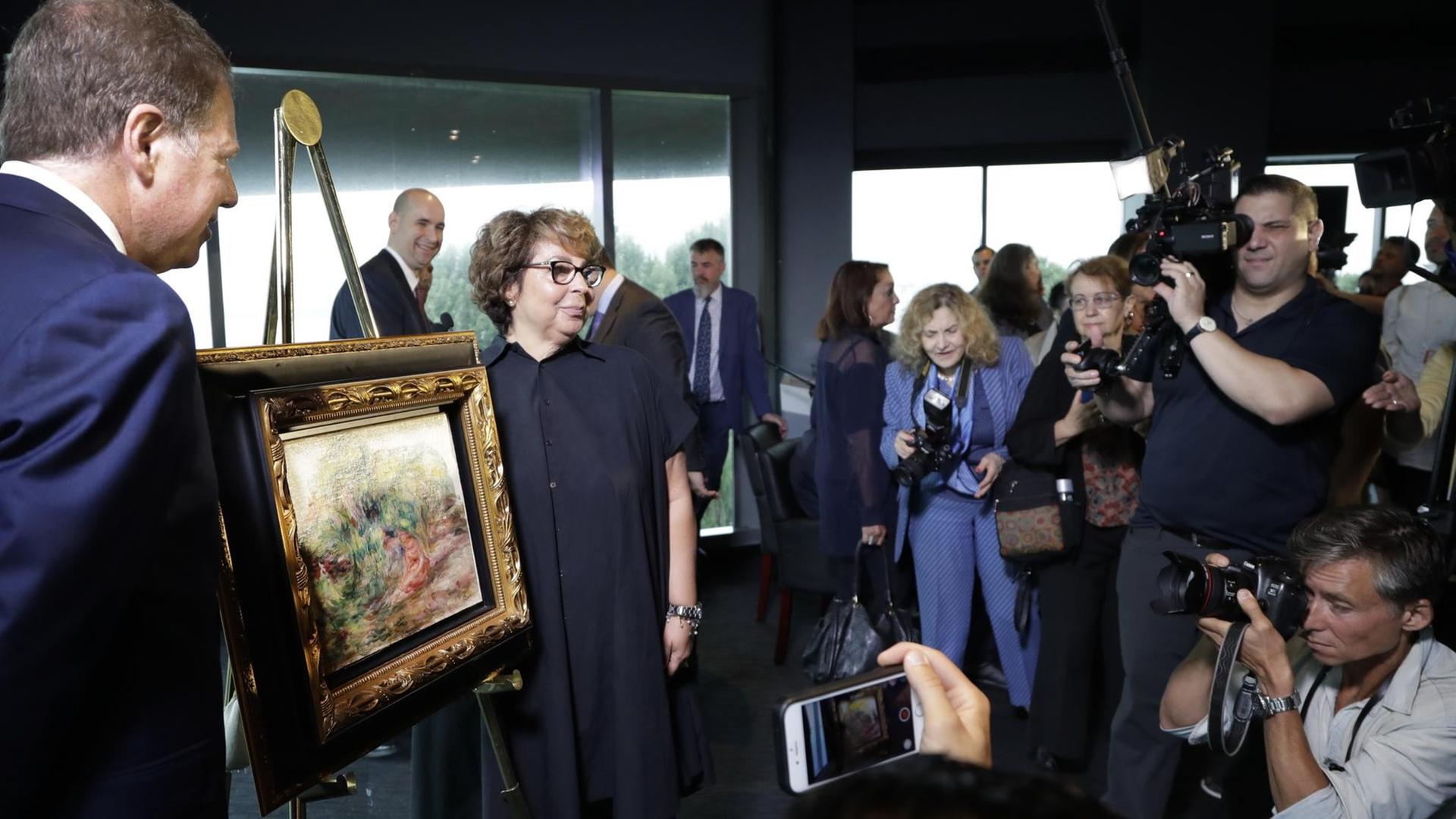 Journalisten fotografieren die Rückgabe des Renoir-Bildes "Frauen im Garten" an Sylvie Sulitzer.