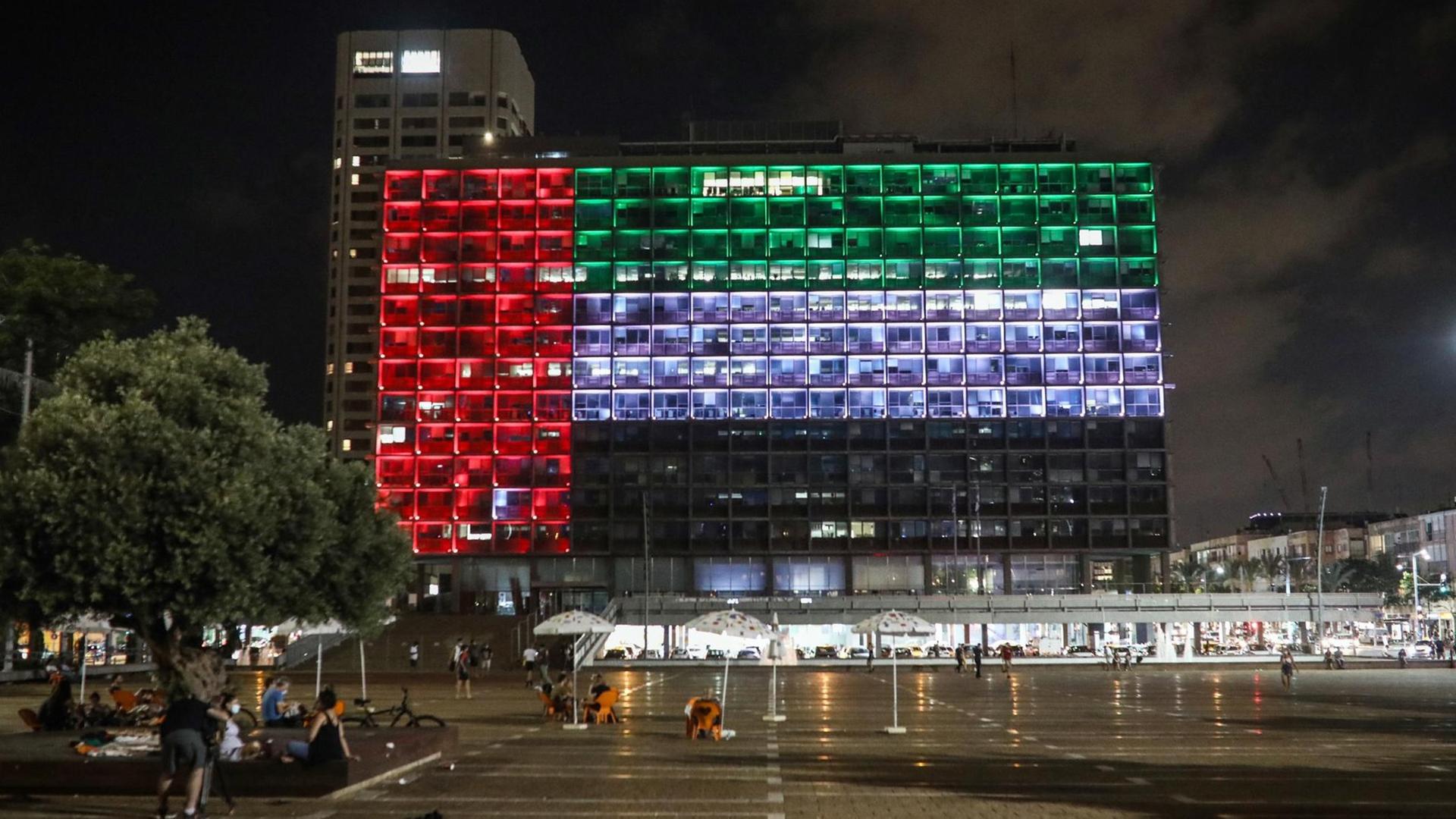 Die Fenster vom Rat-Haus in der Stadt Tel Aviv in Israel leuchten so, dass es aussieht wie die Flagge von den Vereinigten Arabischen Emiraten.