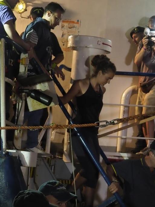 Die deutsche Kapitänin der "Sea Watch 3", Rackete, wird nach der Ankunft in Lampedusa von der Polizei vom Schiff eskortiert.