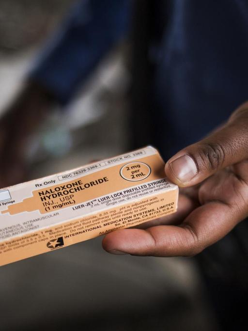 Ein Polizist aus Philadelphia hält eine Packung mit einem Gegenmittel bei Opioid-Vergiftungen in der Hand. Die werden im ganzen Land verteilt.