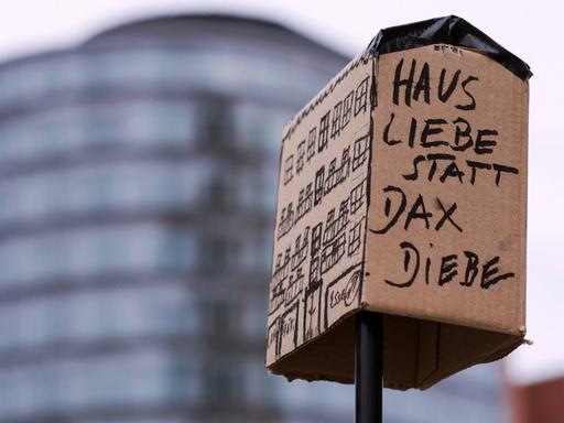 "Haus Liebe statt Dax Diebe" seht auf einem als Protestplakat funktionierenden Haus aus Pappe.