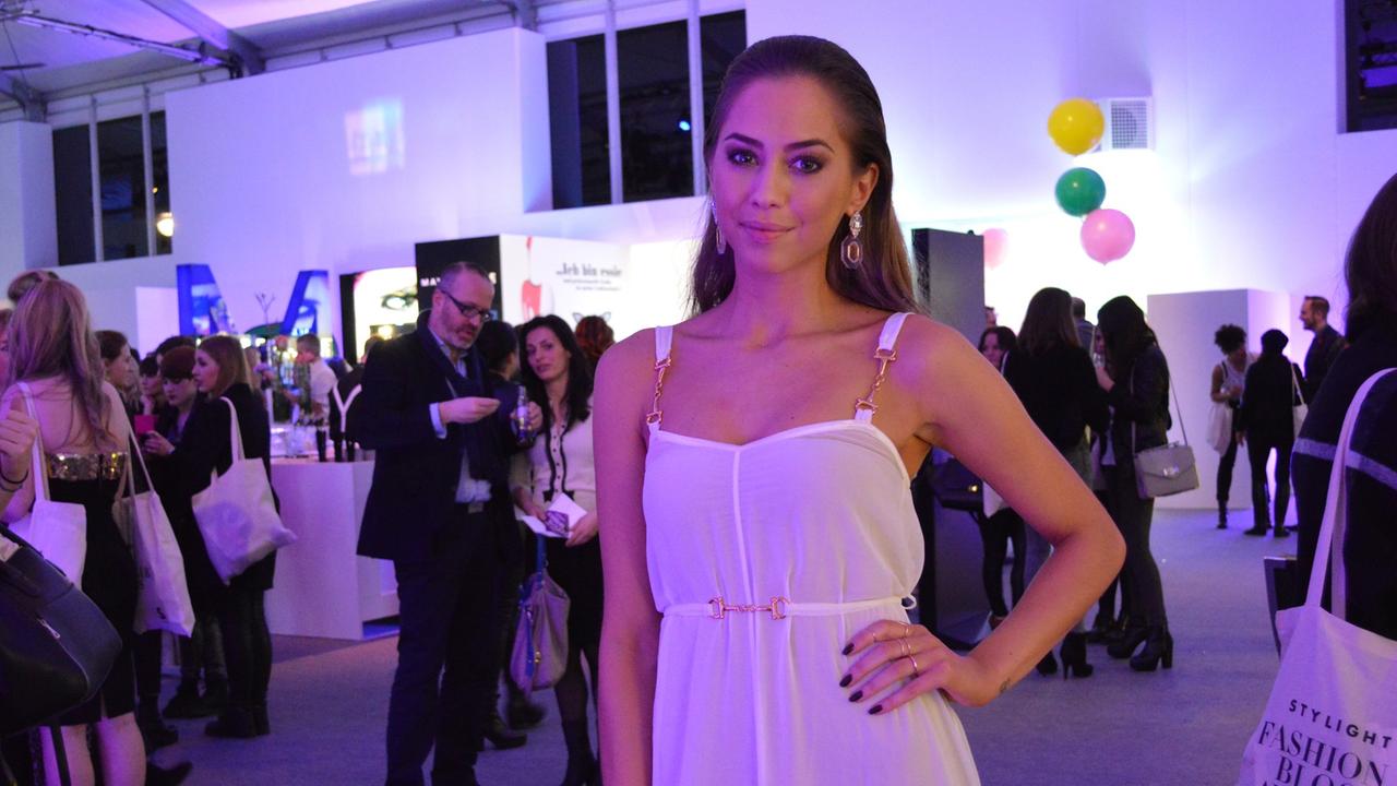 Die schwedische Bloggerin Kenza Zouiten steht in einem weißen Kleid auf der Berlin Fashion Week.