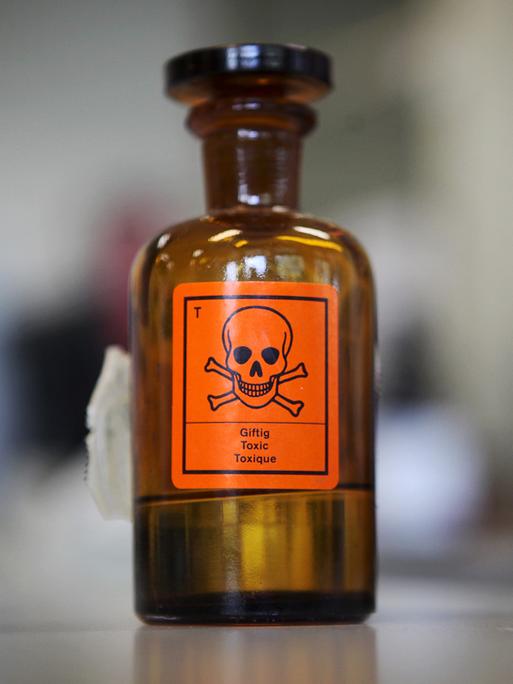 Eine Chemieglasflasche mit einem Aufkleber für "giftig" und einem Totenkopf-Symbol