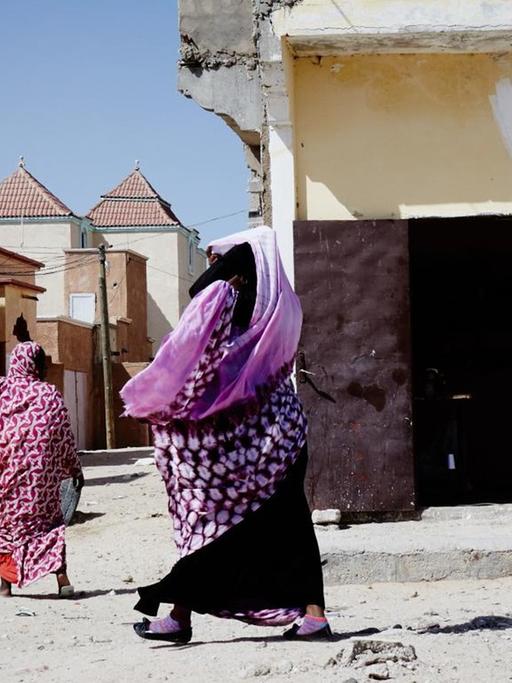 Zwei verschleierte Frauen auf einer sandigen Straße in Mauretaniens Hauptstadt Nouakchott