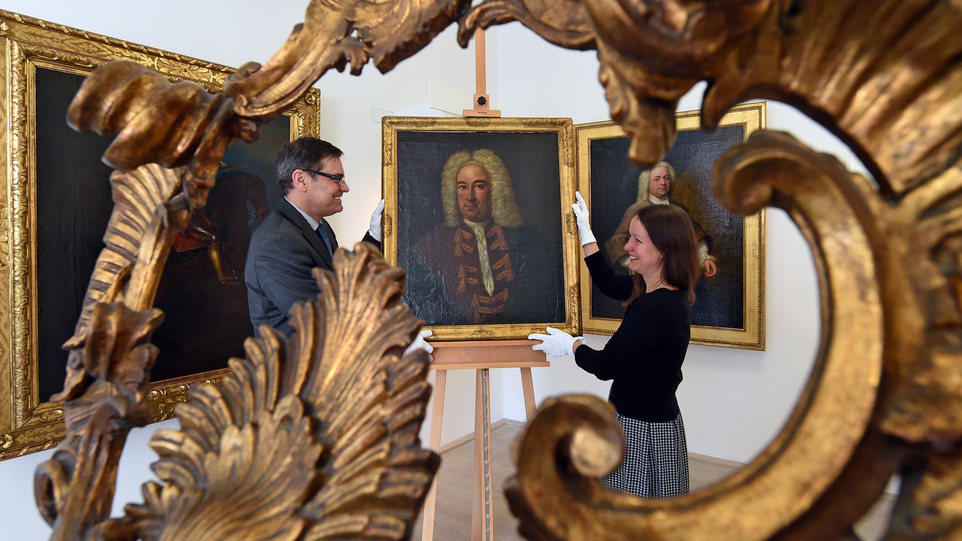 Ein Porträt, das mit höchster Wahrscheinlichkeit Georg Friedrich Händel zeigt, platzieren Clemens Birnbaum, Direktor der Stiftung Händel-Haus und Mitarbeiterin Christiane Barth im Händel-Haus in Halle.